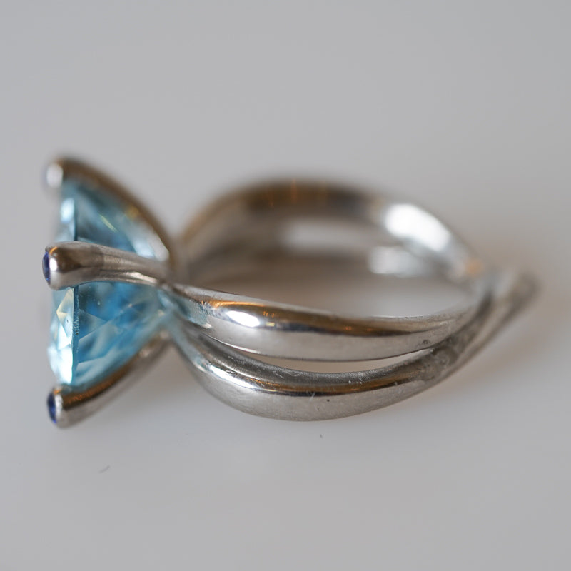 A platinum ring with a large aquamarine gemstone and blue sapphires, designed by Gudrun Hillmann