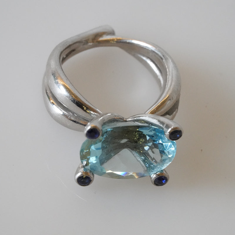 A platinum ring with a large aquamarine gemstone and blue sapphires, designed by Gudrun Hillmann, Front