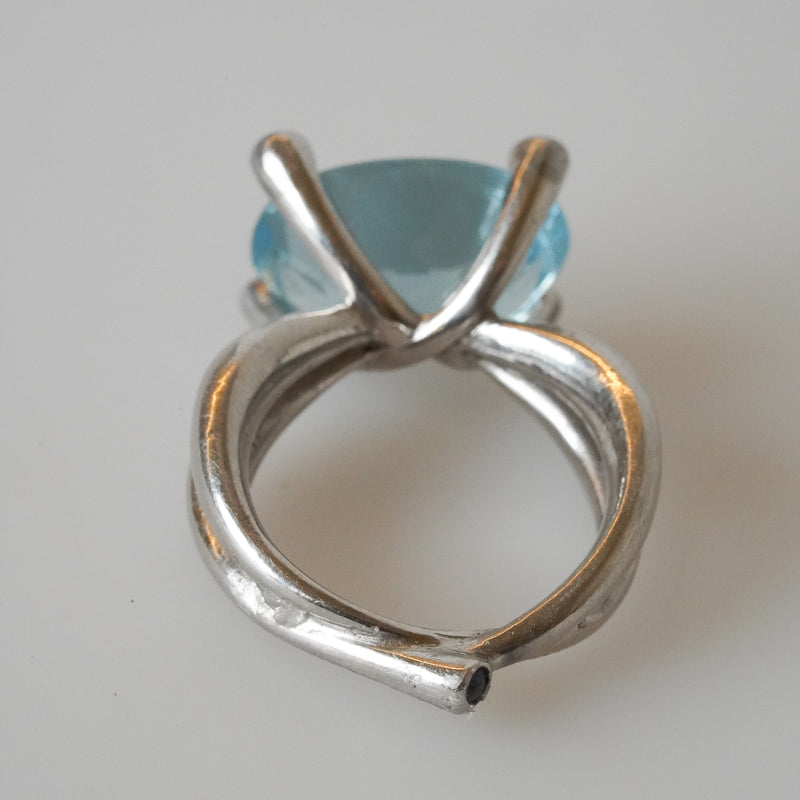 A platinum ring with a large aquamarine gemstone and blue sapphires, designed by Gudrun Hillmann back